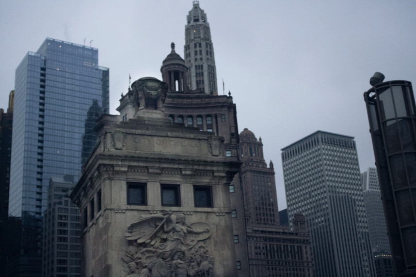 Looking up at the Michigan Avenue Bridge relief marked “City of Chicago,” this moody December shot captures towering buildings through winter fog, showcasing the city's historic and modern architecture in a single frame.